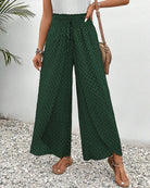 Damenhose in Grün mit weitem Bein und geometrischem Muster, ideal für Sommermode. Perfekt kombiniert mit Sandalen und einer Umhängetasche.