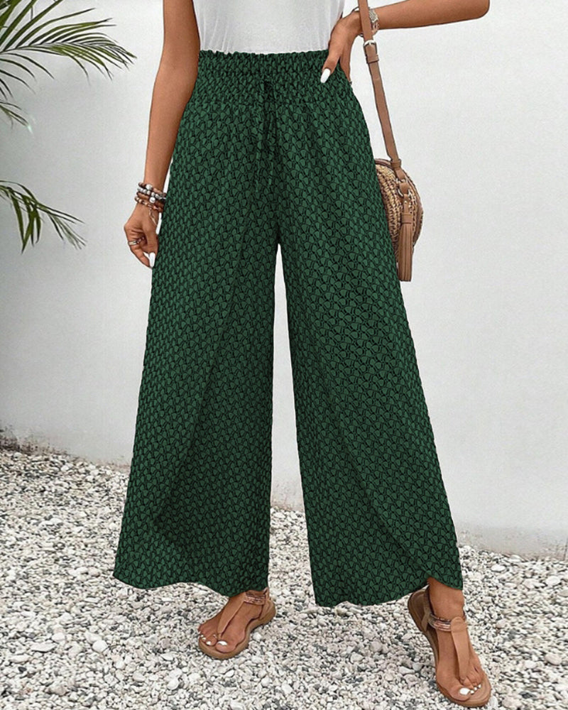 Damenhose in Grün mit weitem Bein und geometrischem Muster, ideal für Sommermode. Perfekt kombiniert mit Sandalen und einer Umhängetasche.