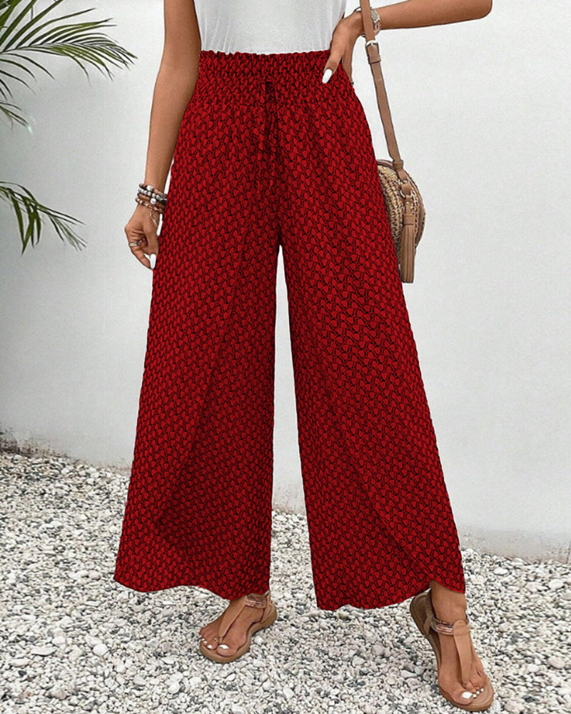 Rote Damenhose mit weitem Bein und geometrischem Muster, ideal für Sommermode. Perfekt kombiniert mit Sandalen und Accessoires.
