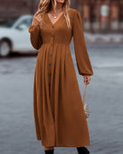 Elegantes braunes Maxikleid mit V-Ausschnitt und Knopfleiste, ideal für Herbstmode. Perfekt für stilvolle Anlässe und trendige Outfits.