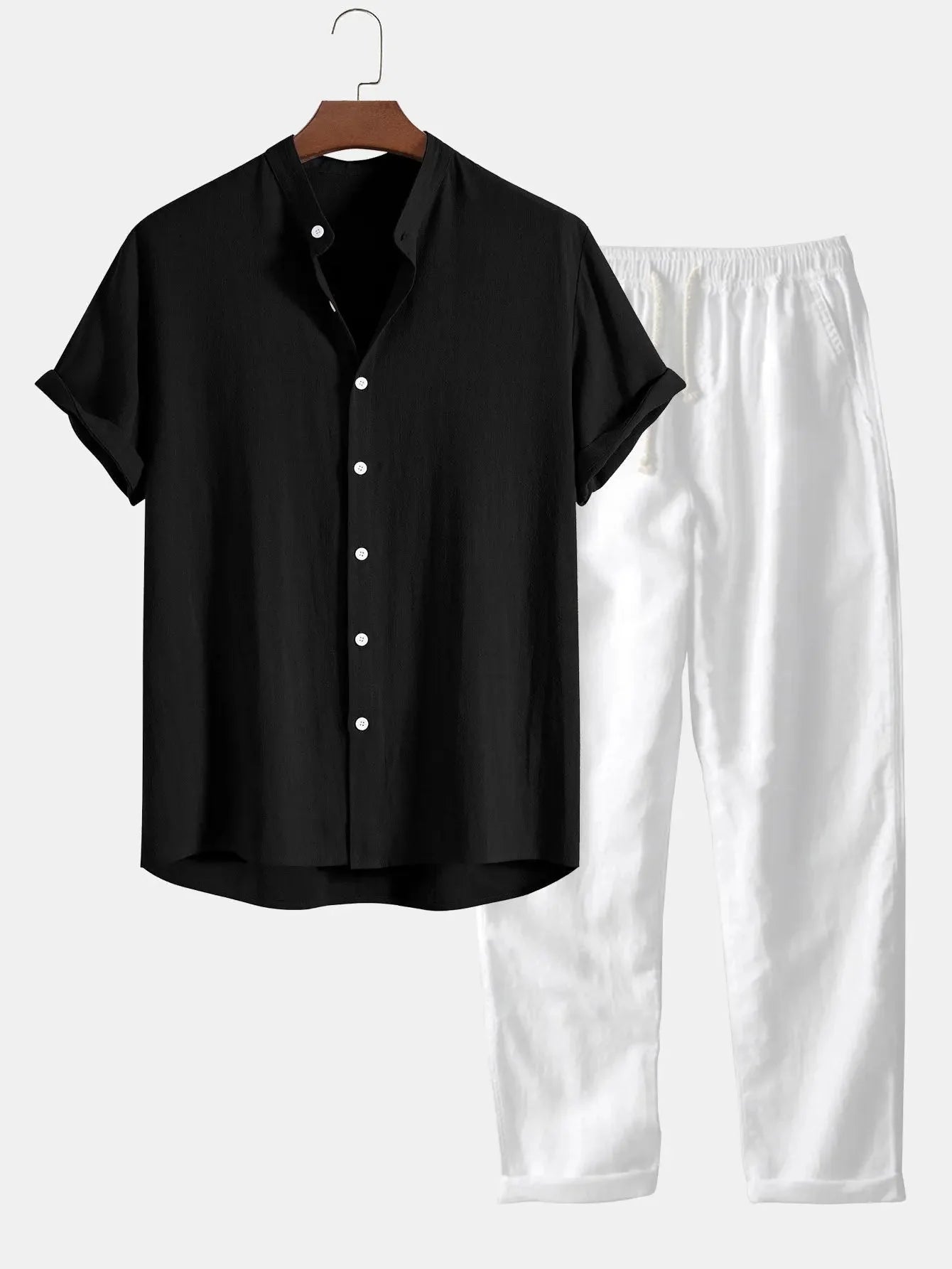 Schwarzes Kurzarmhemd mit weißen Knöpfen, kombiniert mit weißen, locker sitzenden Hosen. Perfekt für lässige Sommermode und stilvolle Outfits.