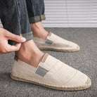 Beige Espadrilles aus Leinen für Herren, kombiniert mit hochgekrempelten Jeans. Perfekt für lässige Sommermode und bequemen Alltagsstil.