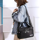 Frau mit schwarzer Umhängetasche aus Nylon, lässiger Stil, modisches Accessoire.