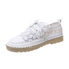 Weißer Damen-Sneaker mit Blumenmuster, Espadrille-Sohle und Schnürung. Modischer Sommerschuh, ideal für Freizeit und Strand.