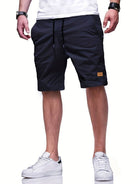 Mann trägt schwarze Shorts, weiße Sneakers, lässiger Stil, Sommermode, Herrenbekleidung.