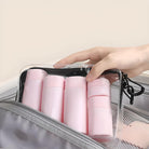 Transparente Kosmetiktasche mit rosa Reisebehältern, ideal für Flugreisen, handlich und stilvoll.