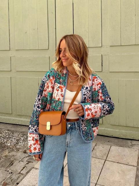 Frau in Vintage-Patchwork-Jacke, Herbstmode 2023. Lässiger Look mit Baumwollmantel, Jeans und brauner Umhängetasche. Trendige Damenbekleidung.