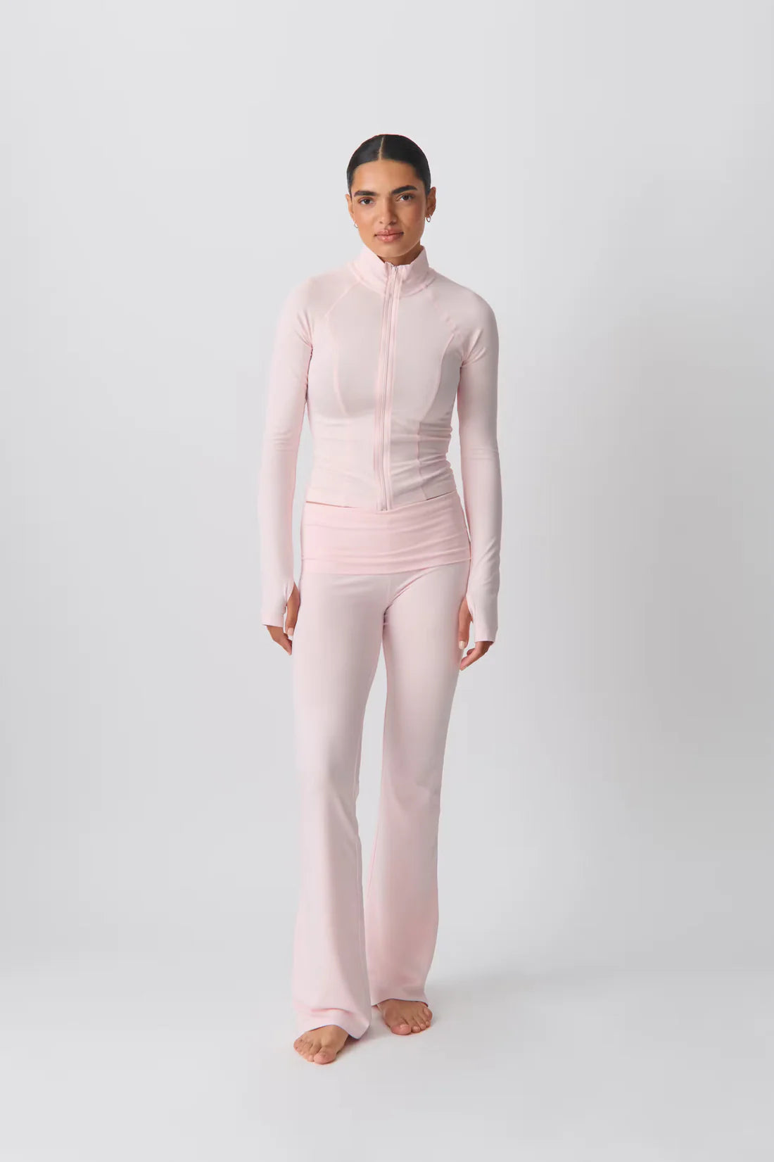 Damen-Sportanzug in Rosa, bestehend aus langärmligem Oberteil und ausgestellter Hose. Ideal für Yoga, Fitness und Freizeitmode.