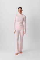 Damen-Sportanzug in Rosa, bestehend aus langärmligem Oberteil und ausgestellter Hose. Ideal für Yoga, Fitness und Freizeitmode.