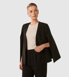 Eleganter schwarzer Cape-Blazer für Damen, ideal für Business- und Abendmode. Stilvoller Look mit modernem Design und hochwertiger Verarbeitung.
