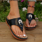 Schwarze Damen-Sandalen mit Keilabsatz, verziert mit Halbmond-Design, ideal für Sommermode. Bequeme, stilvolle Schuhe für Freizeit und Strand.