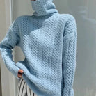 Damen-Pullover aus hellblauer Strickwolle mit Zopfmuster und Rollkragen, ideal für Herbstmode. Bequem, stilvoll und warm.