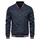 Dunkelblaue Herren-Bomberjacke mit Reißverschluss, gestreiftem Kragen und Bündchen. Modische Übergangsjacke, ideal für Herbst und Frühling.
