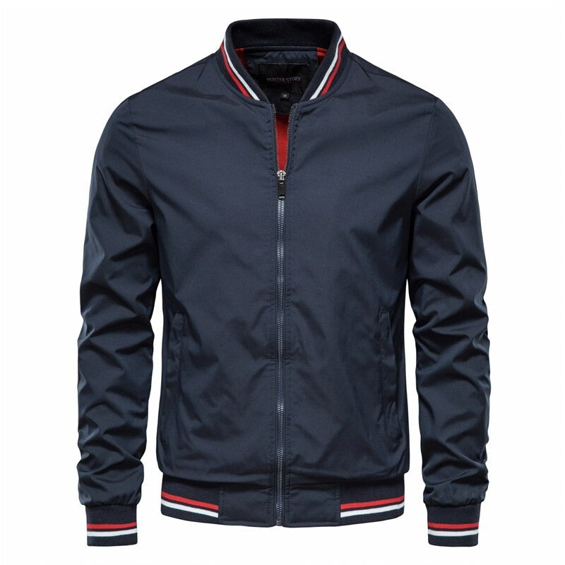 Dunkelblaue Herren-Bomberjacke mit Reißverschluss, gestreiftem Kragen und Bündchen. Modische Übergangsjacke, ideal für Herbst und Frühling.