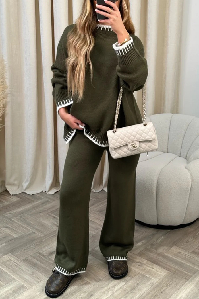 Damen-Outfit: Olivgrüner Strickpullover und Hose mit weißen Details, kombiniert mit einer eleganten, cremefarbenen Designer-Handtasche.