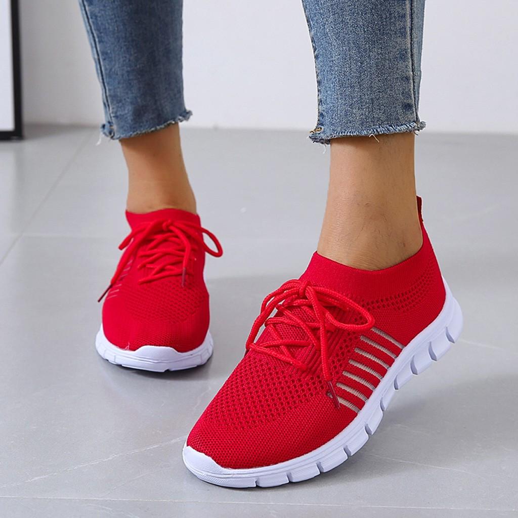 Rote Damen-Sneaker mit weißer Sohle, atmungsaktivem Mesh-Obermaterial und Schnürsenkeln. Perfekt für Sport und Freizeit.