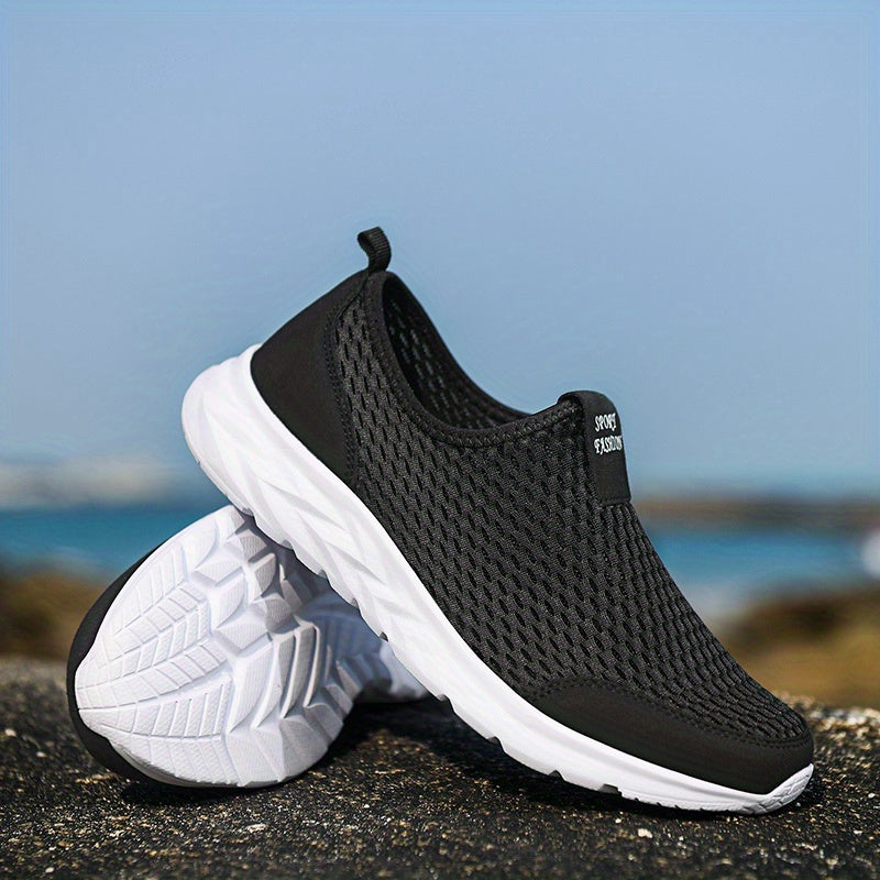 Schwarze, atmungsaktive Sneakers mit weißer Sohle auf Felsen am Meer. Ideal für Sport und Freizeit. Leicht, komfortabel, modisch.