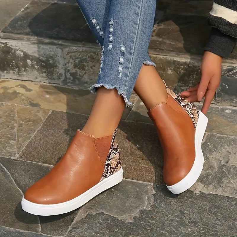 Damen-Sneaker mit braunem Leder und Schlangenmuster, kombiniert mit weißer Sohle. Modische, bequeme Schuhe für den Alltag.