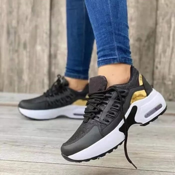 Schwarze Sneaker mit goldenen Akzenten, weißer Sohle und modernem Design. Perfekt für Damenmode, Freizeit und sportlichen Stil.