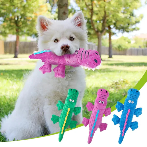 Weißer Hund im Park mit rosa Dinosaurier-Plüschtier im Maul. Hundespielzeug, Plüschdinosaurier, Haustierbedarf, Outdoor-Spielzeug.