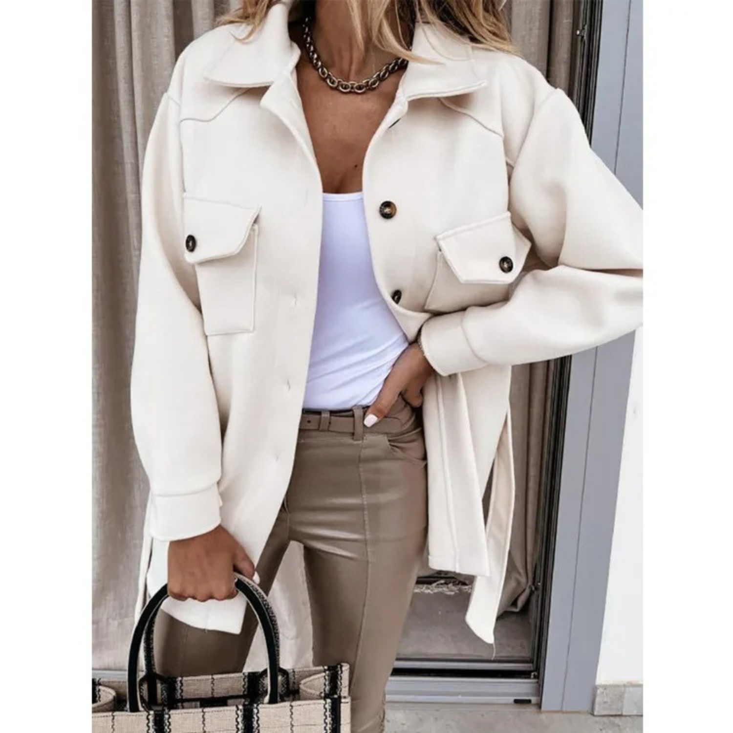Damenmode: Elegante beige Jacke mit Knopfleiste und Brusttaschen, kombiniert mit weißem Top und beiger Hose. Perfekt für stilvolle Herbstlooks.