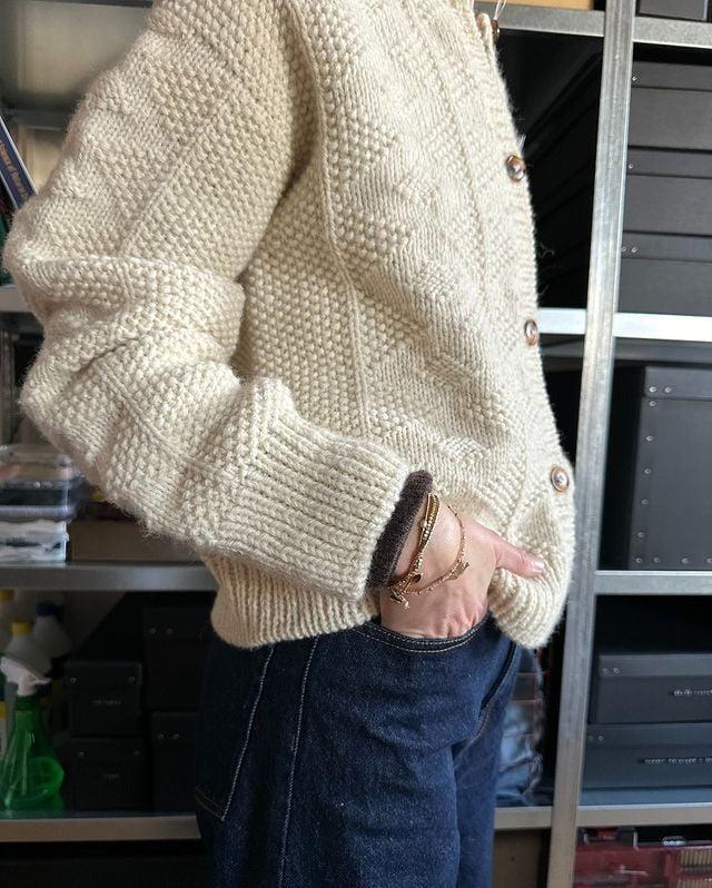 Beige Strickjacke aus Wolle, handgefertigt, mit Holzknöpfen. Perfekt für Herbstmode, kombiniert mit dunkelblauer Jeans. Ideal für gemütliche Outfits.