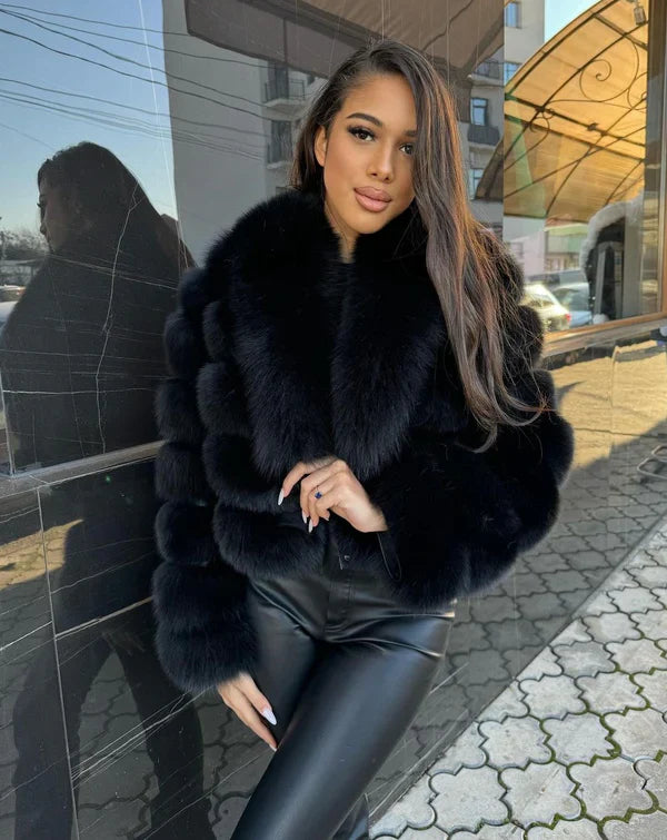 Frau in eleganter schwarzer Pelzjacke und Lederhose, posiert stilvoll draußen. Mode, Winterkleidung, luxuriöser Look, urbane Eleganz.