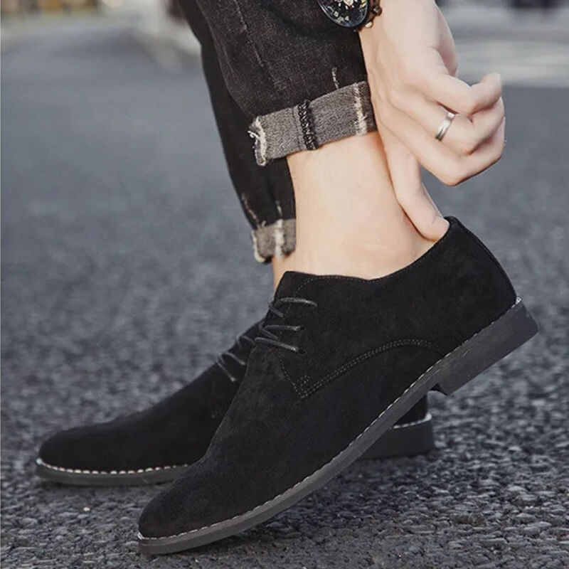 Schwarze Wildleder-Herrenschuhe, lässig, elegant, Straßenhintergrund, modisch, bequem.