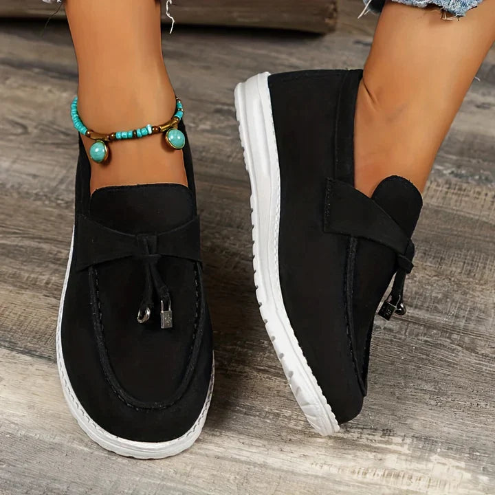 Schwarze Damen-Loafer mit weißer Sohle, modisch und bequem, ideal für Freizeit und Alltag. Perfekt kombinierbar mit Jeans und Schmuck.