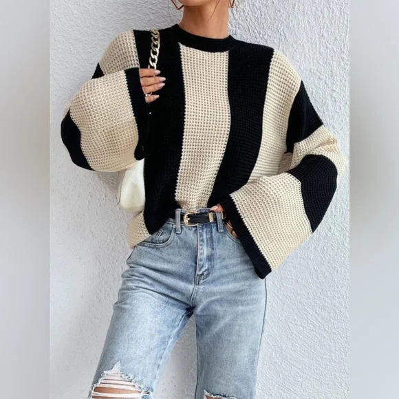 Damenpullover mit schwarz-beigen Blockstreifen, grob gestrickt. Modischer Look mit weiten Ärmeln, ideal für Herbstmode und Streetstyle.