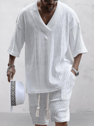 Herren Sommer Outfit: Weißer Strickpullover mit V-Ausschnitt und passender Shorts. Perfekt für lässige, stilvolle Sommermode.