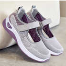 Damen-Sneaker in Grau mit atmungsaktivem Mesh, Klettverschluss und lila Akzenten. Bequeme, modische Schuhe für Alltag und Sport.