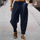 Mann trägt schwarze Leinenhose und Sandalen auf Gehweg, lässige Sommermode.