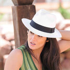 Frau mit weißem Panama-Hut und schwarzem Band, Sommermode, stilvoller Look.