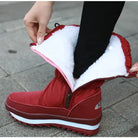 Rote Winterstiefel mit Reißverschluss und weißem Futter, ideal für kalte Tage. Wasserdicht, warm, rutschfest. Perfekt für Damenmode im Winter.