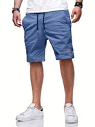 Mann trägt blaue Herren-Shorts, lässig, mit Taschen, kombiniert mit weißen Sneakers.