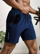 Mann in dunkelblauer Sportshorts mit Reißverschlusstaschen, ideal für Fitness und Training.