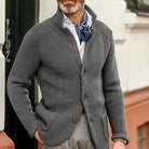 Grauer Strick-Cardigan für Herren, stilvoll kombiniert mit weißem Hemd und blauem Halstuch. Perfekt für elegante Herbst- und Wintermode.