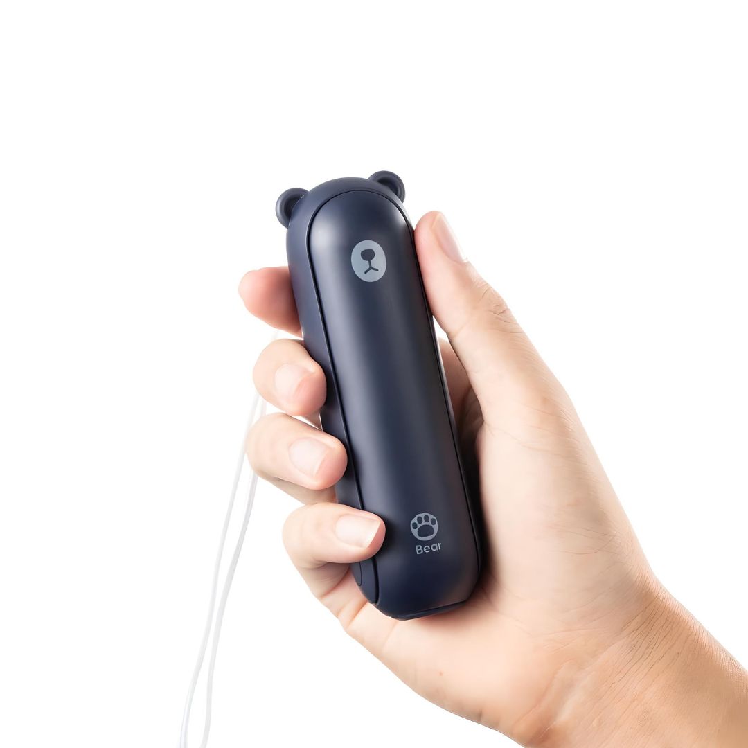Hand hält schwarzen tragbaren Mini-Ventilator in Bärenform mit USB-Anschluss.