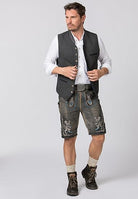 Mann in traditioneller bayerischer Tracht: graue Weste, weiße Hemd, Lederhose mit Stickerei, Trachtenschuhe. Perfekt für Oktoberfest-Outfits.