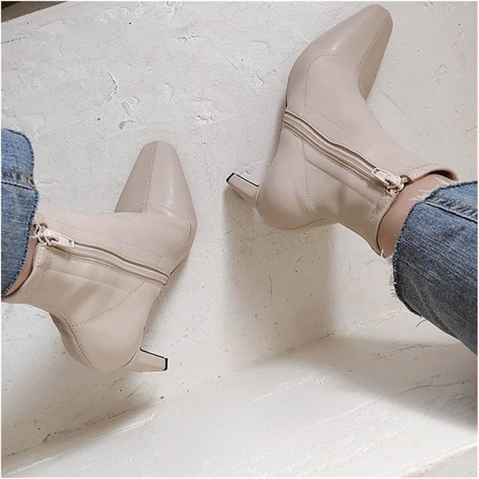 Beige Stiefeletten mit spitzem Absatz und seitlichem Reißverschluss, kombiniert mit blauen Jeans. Modische Damenstiefel für Herbst und Winter.