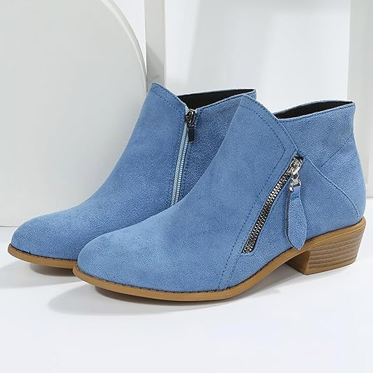 Blaue Damen-Stiefeletten aus Wildleder mit seitlichem Reißverschluss, flachem Absatz und modernem Design. Perfekt für Herbstmode und Alltagslooks.