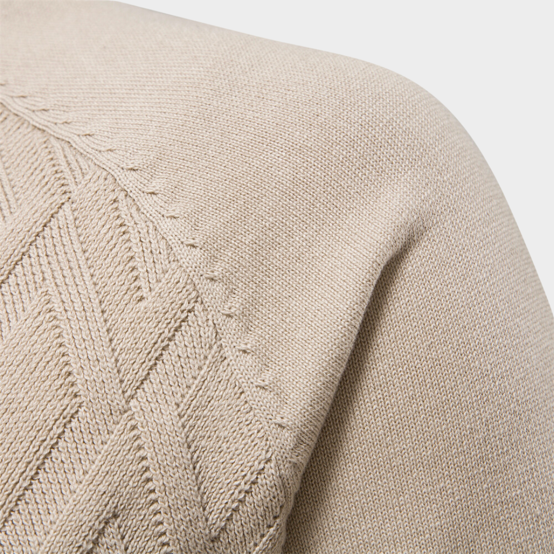 Beiges Strickpullover-Detail mit Zopfmuster, weiche Baumwolle, modisch, hochwertig, ideal für Herbstmode, stilvoll und bequem.