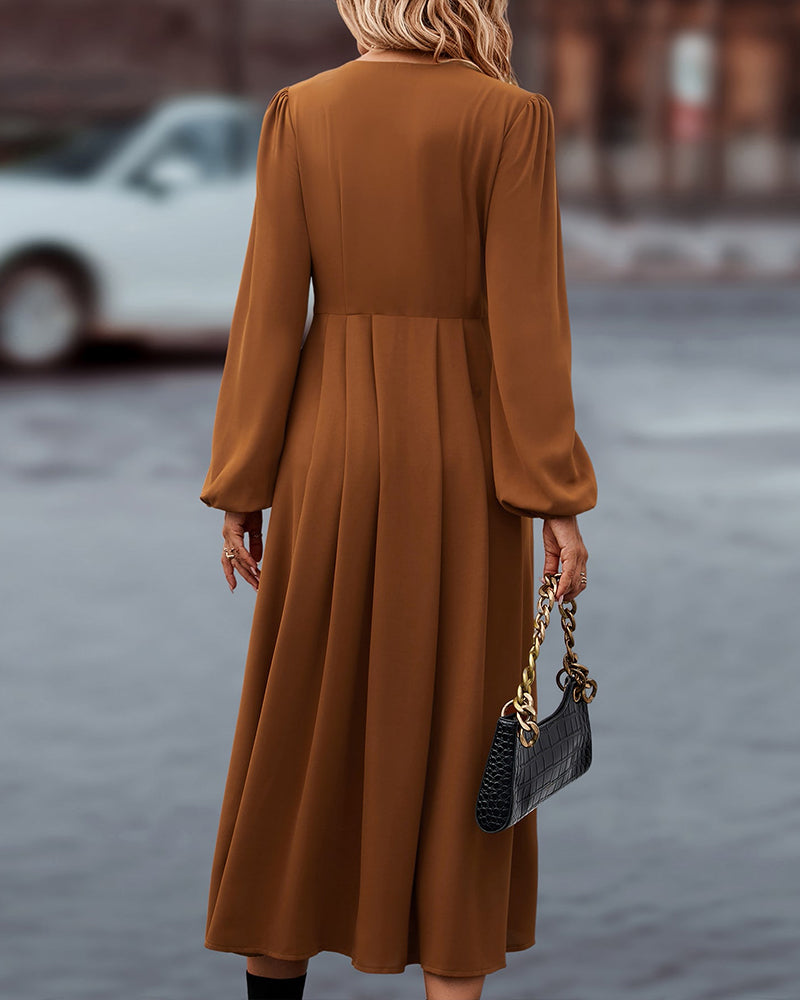 Damenkleid in Braun, langärmelig, fließend, elegantes Design. Perfekt für Herbstmode, kombiniert mit schwarzer Handtasche. Ideal für stilvolle Anlässe.