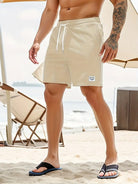 Mann in beigen Badeshorts am Strand, Sommermode, Freizeitkleidung, Herrenmode, Sandalen.
