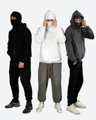 Drei Männer in schwarzen, weißen und grauen Hoodies und Jogginghosen, modische Streetwear.
