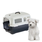 Transportbox für Haustiere mit robustem Kunststoffdesign, ideal für Reisen. Neben der Box sitzt ein kleiner, weißer Hund. Perfekt für Hunde und Katzen.