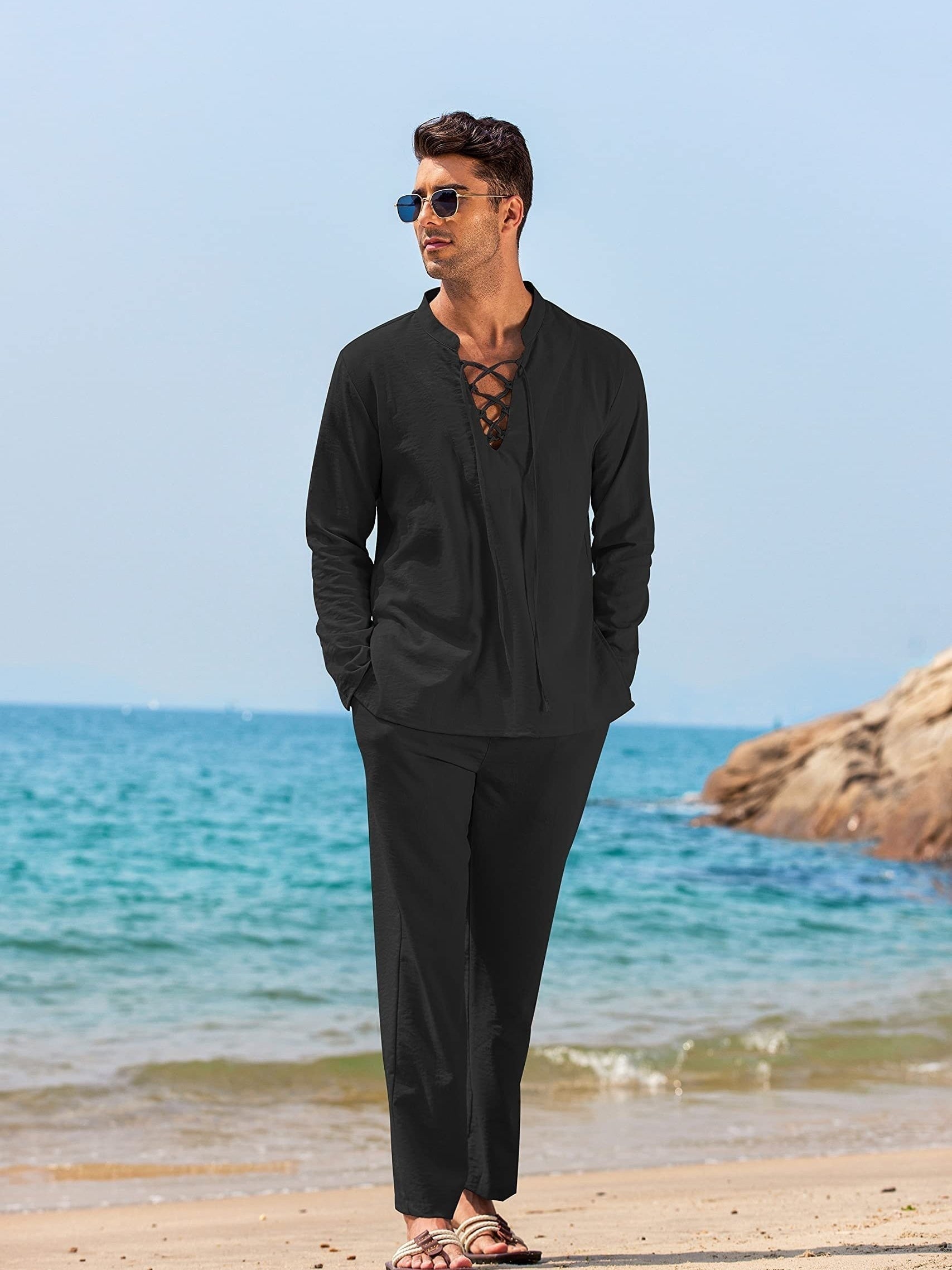 Mann in schwarzem Leinenanzug am Strand, lässiger Sommerlook, ideal für Herrenmode, Strandkleidung, stilvolle Freizeitoutfits.