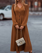 Damen Maxikleid in Braun mit Knopfleiste, V-Ausschnitt und langen Ärmeln. Elegantes Design, ideal für Herbstmode. Perfekt mit gesteppter Handtasche.
