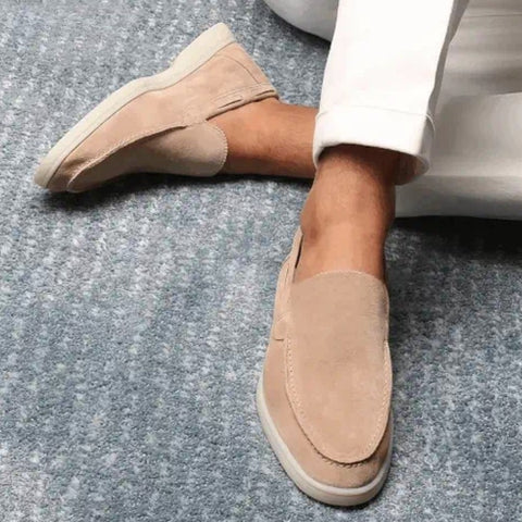 Beige Wildleder-Loafer für Herren auf grauem Teppich. Stilvolle, bequeme Schuhe, ideal für Freizeit- und Business-Outfits. Elegante Herrenschuhe.